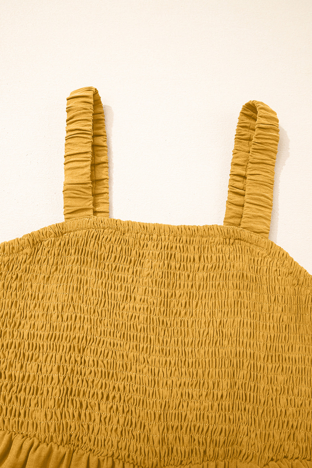 Mono color mostaza,  sin mangas, de pierna ancha y con fruncido, con bolsillos.