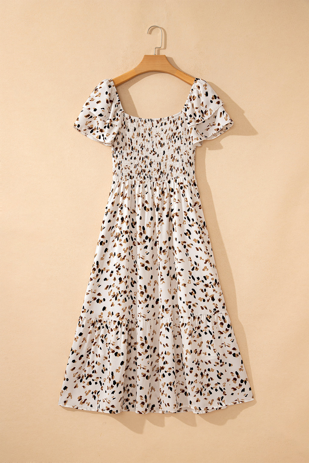 Vestido corto beige con estampado floral discreto, cuello cuadrado fruncido y mangas cortas con volantes.