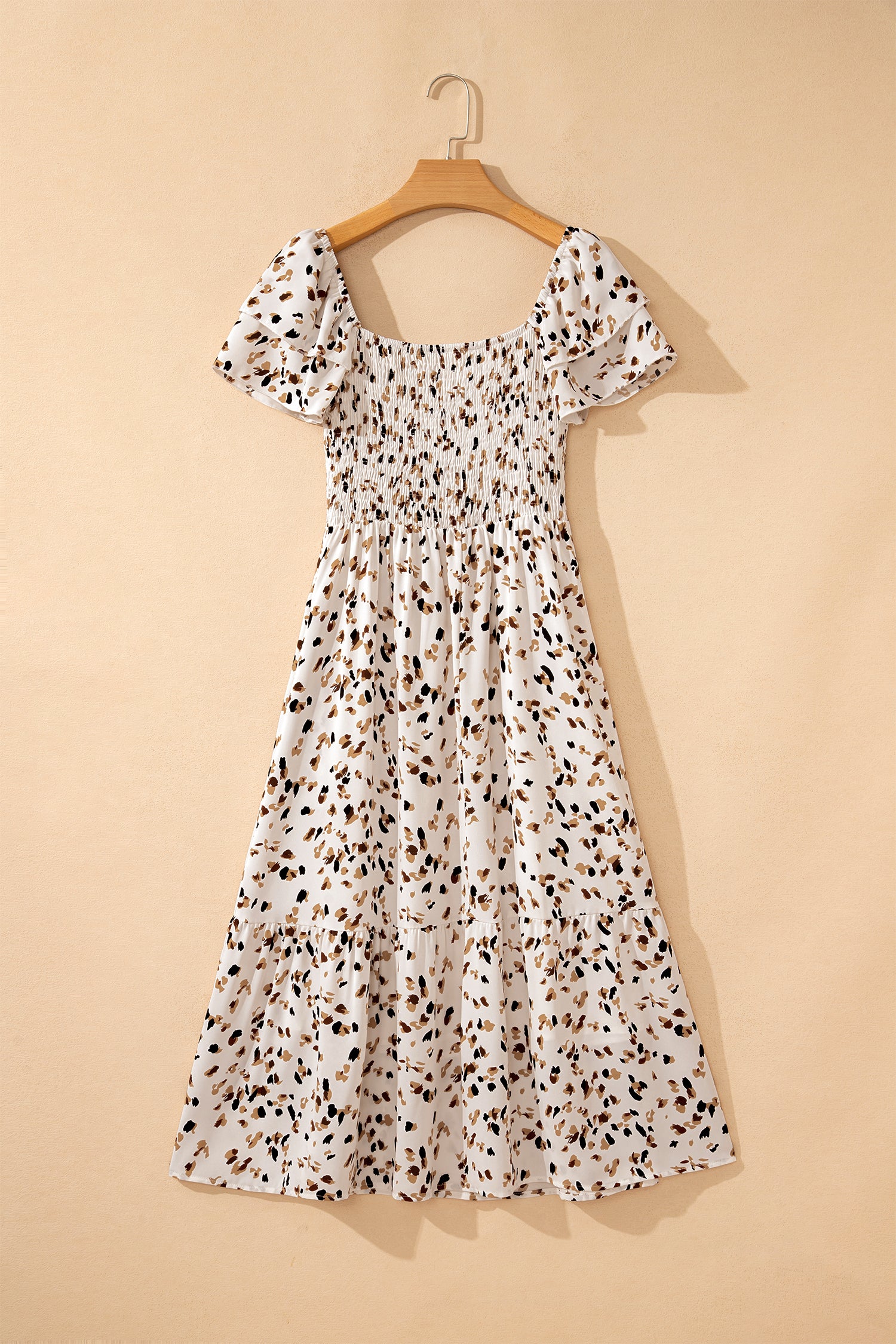 Vestido corto beige con estampado floral discreto, cuello cuadrado fruncido y mangas cortas con volantes.