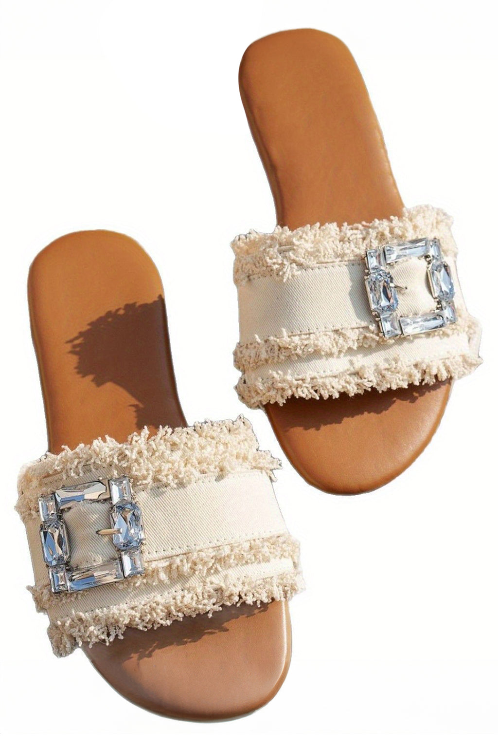 sandalia blancas con detalle de hebilla de pedrería y banda ancha deshilachada.