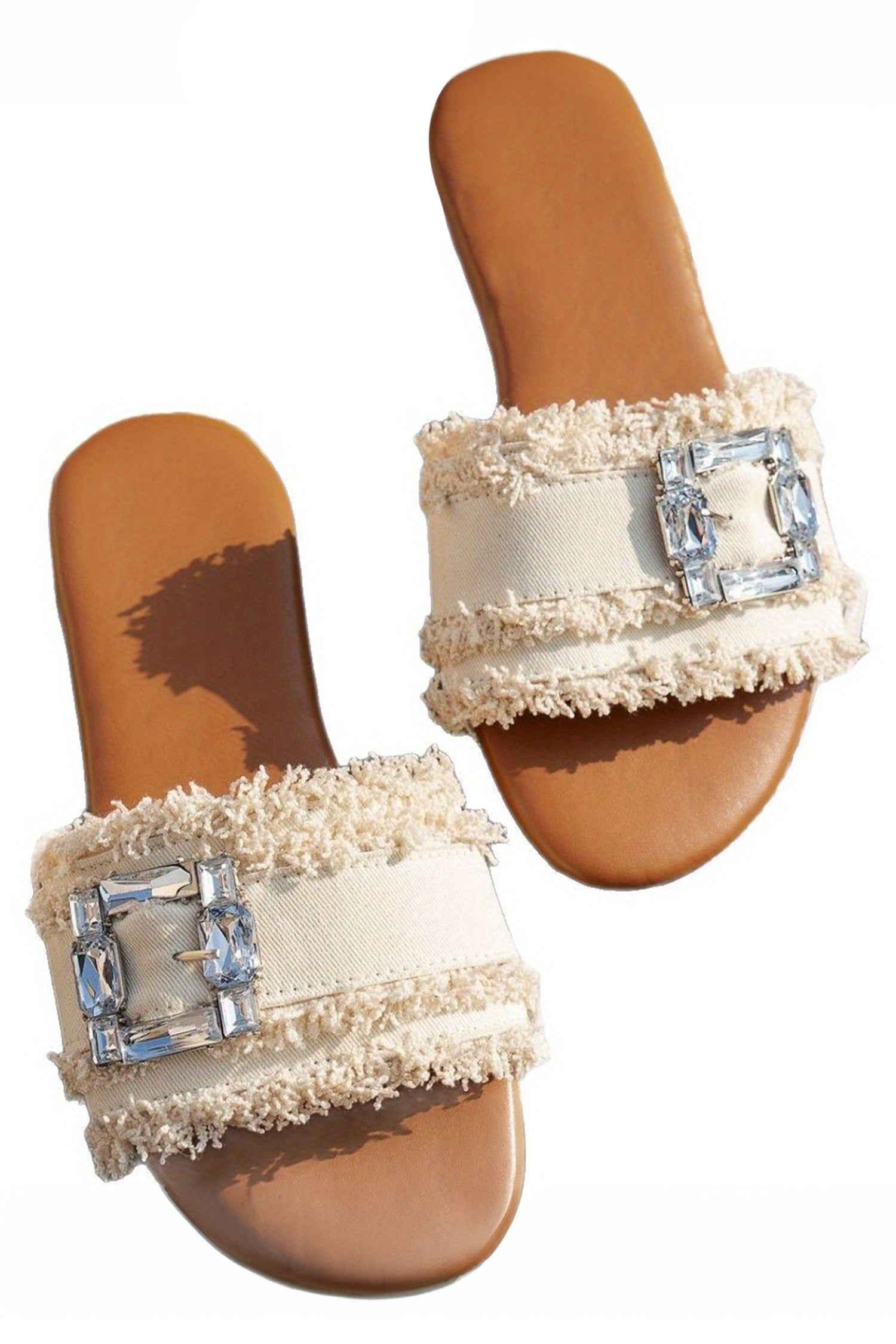 sandalia blancas con detalle de hebilla de pedrería y banda ancha deshilachada.
